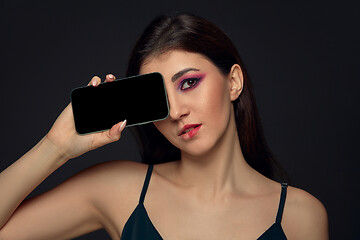 Image showing Lie and another life in social media. Girl with make up only on half of her face. Playing pretend. Blank phone screen.