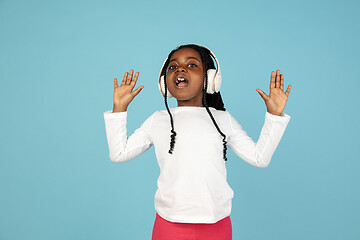 Image showing Handsome african little girl portrait isolated on blue studio background with copyspace