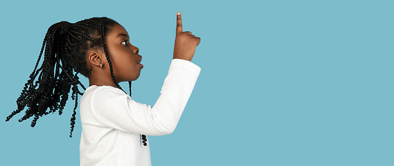 Image showing Handsome african little girl portrait isolated on blue studio background with copyspace