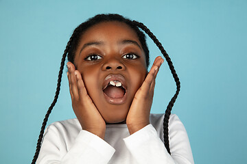 Image showing Handsome african little girl portrait isolated on blue studio background with copyspace