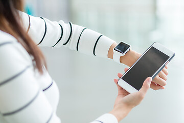 Image showing Woman using smart watch connecting with cellphone