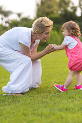 Image showing mother and little daughter playing at backyard