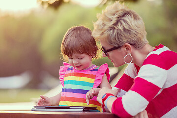 Image showing mom and her little daughter using tablet computer