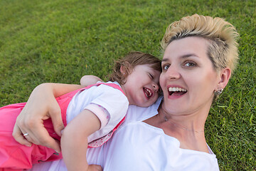 Image showing mother and little daughter playing at backyard