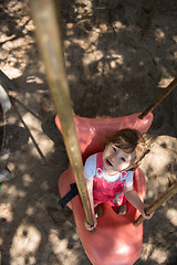 Image showing little girl swinging  on a playground