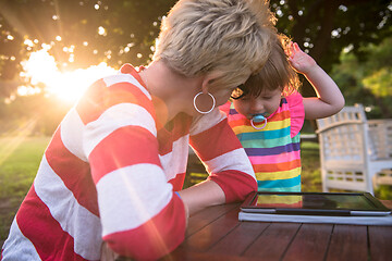 Image showing mom and her little daughter using tablet computer