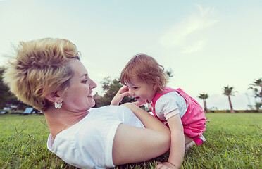 Image showing mother and little daughter playing at backyard