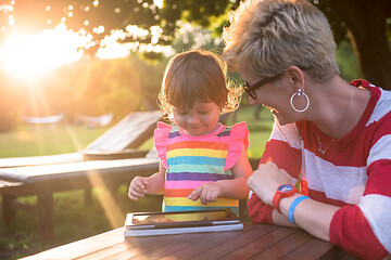 Image showing mom and her little daughter using tablet computer