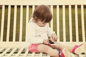 Image showing little girl playing with mobile phone