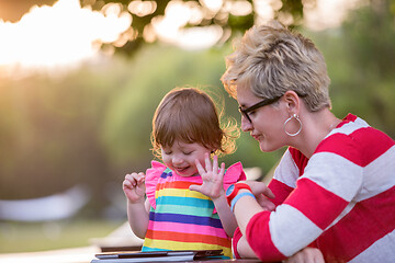 Image showing mom and her little daughter using tablet computer