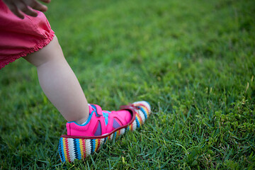 Image showing little Girl wearing big shoes of her mother