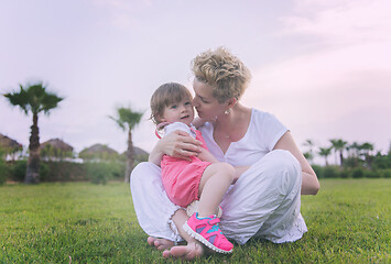 Image showing mother and little daughter playing at backyard