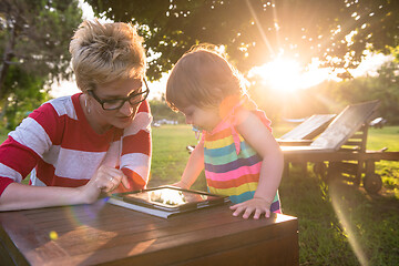 Image showing mom and her little daughter using tablet computer