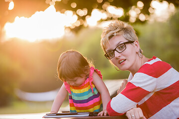 Image showing mom and her little daughter using tablet computer