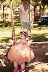 Image showing mother and daughter swinging in the park