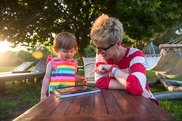 Image showing mom and her little daughter using tablet computer