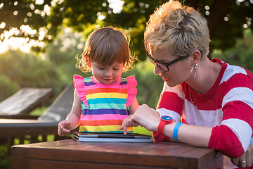 Image showing mom and her little daughter using tablet computer