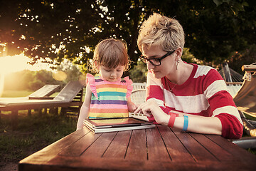 Image showing mom and her little daughter using tablet computer