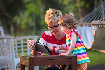 Image showing mom and her little daughter using tablet computer