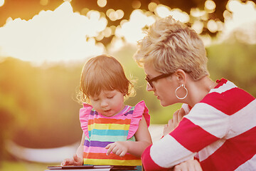 Image showing mom and her little daughter using tablet computer