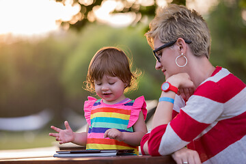 Image showing mom and her little daughter using tablet computer