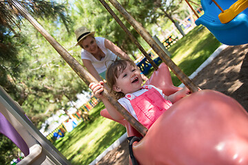 Image showing mother and daughter swinging in the park