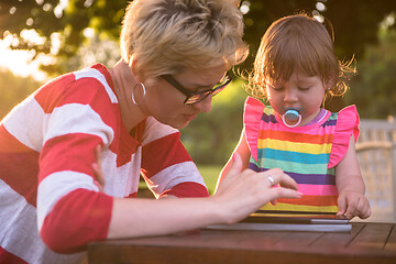 Image showing mom and her little daughter using tablet computer