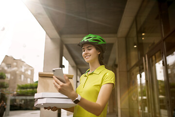 Image showing Young woman as a courier delivering pizza using gadgets