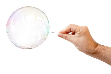 Image showing soap bubble and a males hand with needle to let it pop