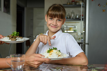 Image showing Happy girl chose one dish out of two offered by her mother for lunch