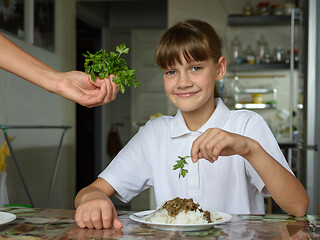 Image showing Mom offers greens for daughter\'s dinner, daughter happily looks into the frame