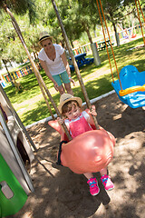 Image showing mother and daughter swinging in the park