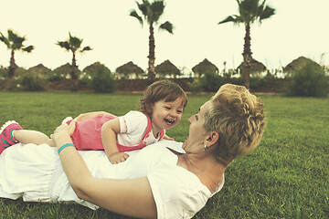 Image showing mother and little daughter playing at backyard