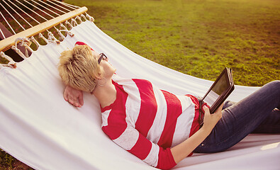 Image showing woman using a tablet computer while relaxing on hammock