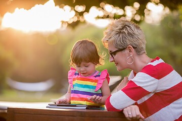 Image showing mom and her little daughter using tablet computer