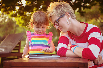 Image showing mom and her little daughter using tablet computer