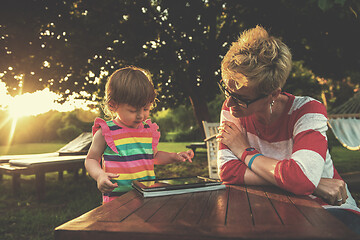 Image showing mom and her little daughter using tablet computer