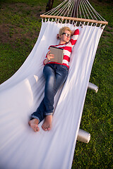 Image showing woman using a tablet computer while relaxing on hammock