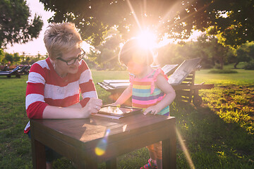 Image showing mom and her little daughter using tablet computer