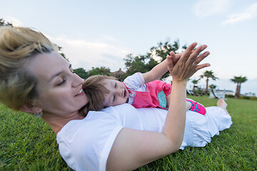 Image showing mother and little daughter playing at backyard