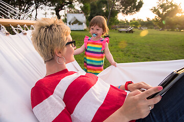 Image showing mom and a little daughter relaxing in a hammock