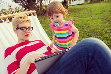 Image showing mom and a little daughter relaxing in a hammock