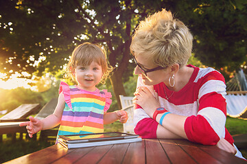 Image showing mom and her little daughter using tablet computer