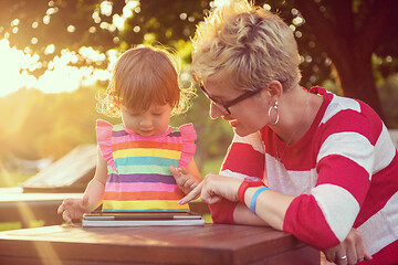 Image showing mom and her little daughter using tablet computer