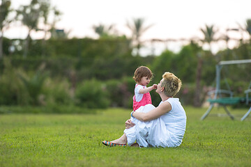 Image showing mother and little daughter playing at backyard