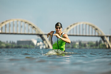 Image showing Professional triathlete swimming in river\'s open water