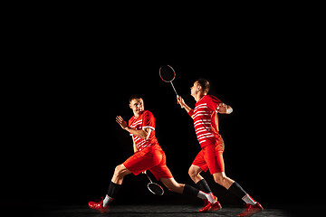 Image showing Young man playing badminton isolated on black studio background