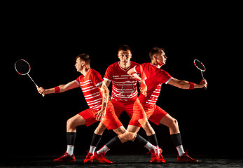 Image showing Young man playing badminton isolated on black studio background