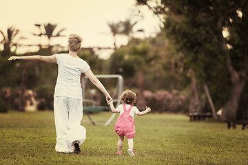 Image showing mother and little daughter playing at backyard