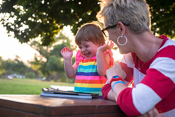 Image showing mom and her little daughter using tablet computer